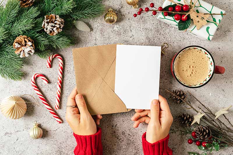 Christmas card being put into an envelope